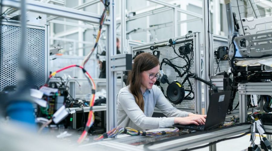 11Engineer analysing machinery data on a laptop in an industrial facility.