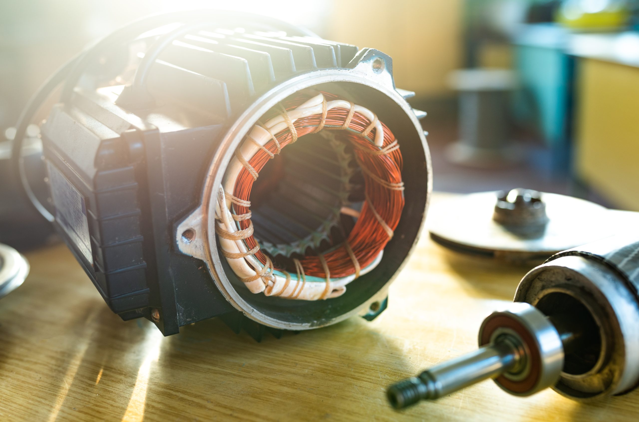 Close-up of iron industrial motor lies on a table 11Electric motor with exposed copper windings and removed components during a repair assessment.