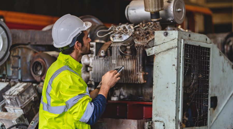 11Engineer inspecting heavy industrial machinery while assessing the need for Predictive Maintenance Services.